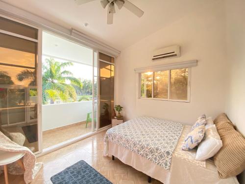 1 dormitorio con cama y ventana grande en Hacienda Iguana Surf & Golf, en Tola