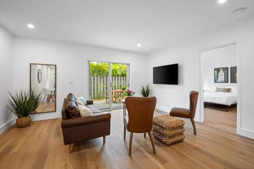 a living room with a couch and chairs and a tv at Sailors Rest @ Sailboat Bend in Fort Lauderdale