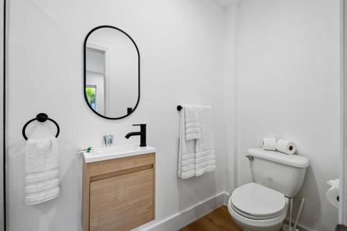 a white bathroom with a toilet and a mirror at Sailors Rest @ Sailboat Bend in Fort Lauderdale
