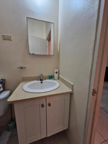 a bathroom with a sink and a mirror at Beautiful 1-Bed House in Old Harbour gated in Old Harbour
