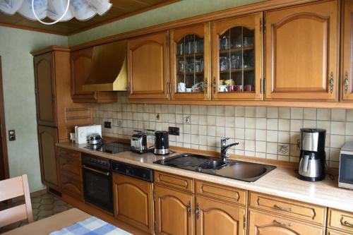 a kitchen with wooden cabinets and a sink at Fewo Adams in Hohenleimbach