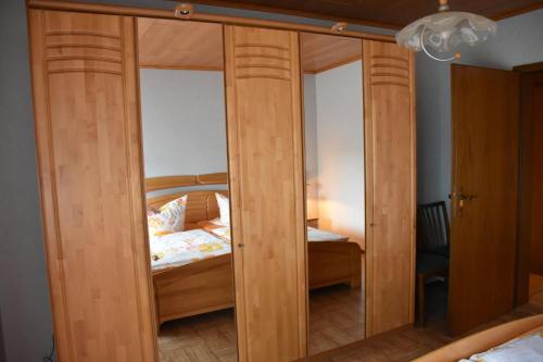 a wooden closet with glass doors in a bedroom at Fewo Adams in Hohenleimbach