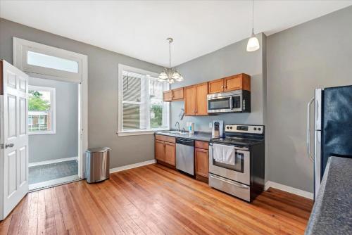 a kitchen with stainless steel appliances and wooden cabinets at Historic First Floor Unit in STL - 5 Bedrooms in Soulard