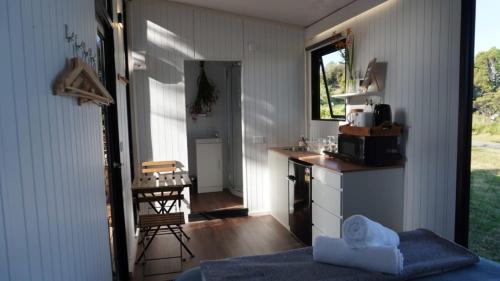 a room with a kitchen and a counter with a table at The Kauri Retreat 1 in Waitoki