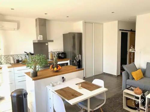 Il comprend une cuisine et un salon avec une table. dans l'établissement petit coin de paradis, à Martigues