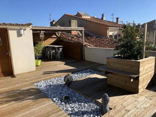 un patio avec une table et une plante en pot sur une terrasse dans l'établissement petit coin de paradis, à Martigues