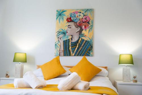 a bedroom with a painting above a bed with yellow pillows at Barclay House Apartment in Fort William