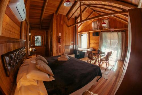 a bedroom with a large bed in a cabin at Hospedaria Refugio do Invernador in Urubici