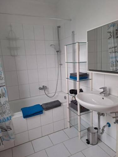 ein weißes Bad mit einem Waschbecken und einer Dusche in der Unterkunft Velbert am Berg in Velbert