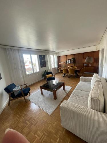un soggiorno con divano e tavolo di magnifique appartement a Parigi