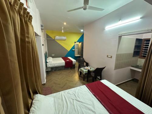 a hotel room with two beds and a window at OM LINGESWARAN HOME STAY Tiruvannamalai in Tiruvannāmalai