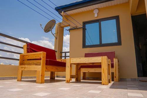 a house with two benches in front of it at Le Nid des Lys in Lomé