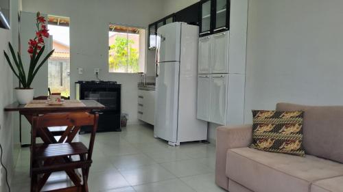 uma cozinha com um sofá, uma mesa e um frigorífico em Achei Casa Seu Espaço Exclusivo no Condomínio Lagoa Azul Topazio em Porto Velho