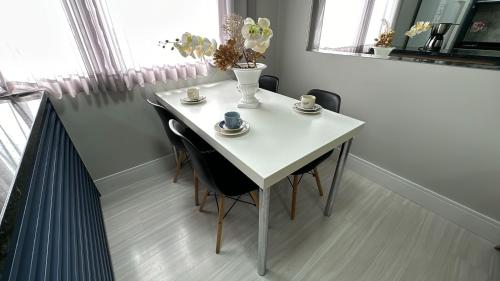 a white table with chairs and cups and a vase on it at 08- Studio perfeito para família! Aconchegante e novo! in Curitiba