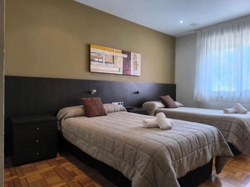1 dormitorio con 2 camas y toallas. en Hotel Santa Barbara, en Andorra