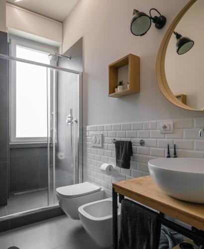 La salle de bains est pourvue d'un lavabo, de toilettes et d'un miroir. dans l'établissement B&B Maradona, à Naples