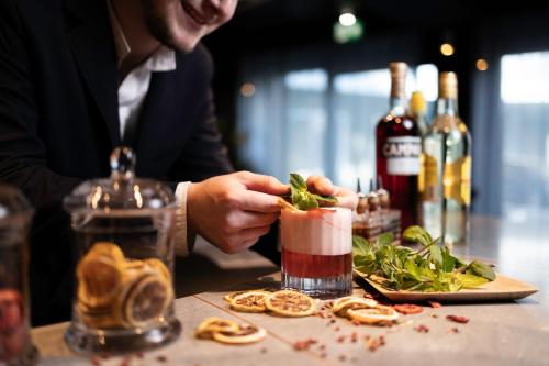 a person is making a drink at a bar at voco Brussels City North by IHG in Vilvoorde