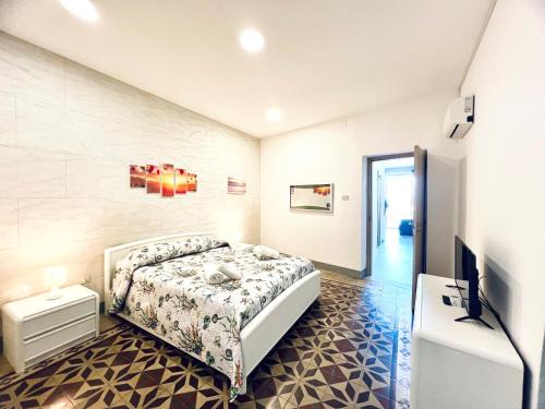 Schlafzimmer mit einem Bett und einem Flachbild-TV in der Unterkunft Casa Nonna Anna in Palermo