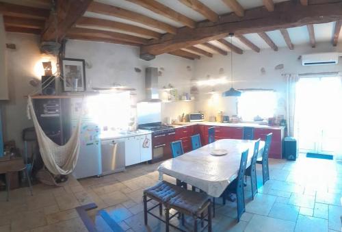 une cuisine avec une table et des chaises dans une pièce dans l'établissement Maison au cœur du Pays-Basque, à Mendionde