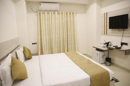 a hotel room with a bed and a television at Hotel- The Yellow Queen in Guwahati