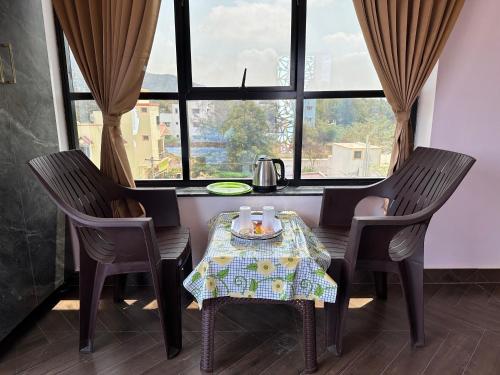 a table with two chairs and a table with drinks on it at OM LINGESWARAN HOME STAY Tiruvannamalai in Tiruvannāmalai