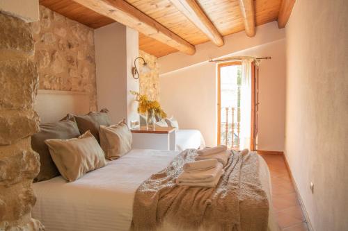 1 dormitorio con 1 cama con toallas en Mas Camins, en Avinyonet de Puigventós