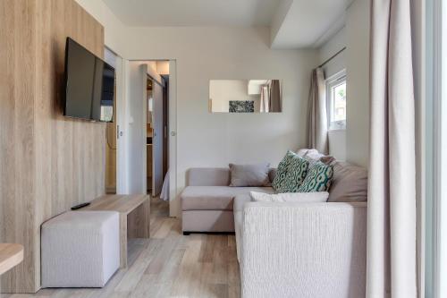 a living room with a couch and a tv at Sangulí Camping & Resort in Salou