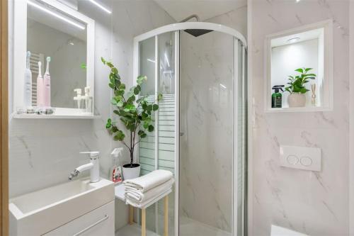 La salle de bains blanche est pourvue d'une douche et d'un lavabo. dans l'établissement Prachtige woning centrum Hasselt, à Hasselt