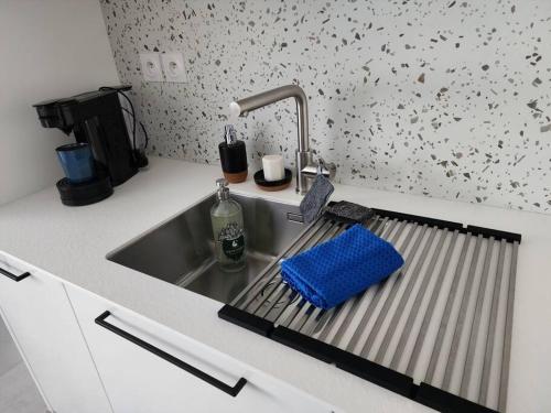 a kitchen sink with a blue towel on it at Appartement Plein Centre in Saint-Brevin-les-Pins