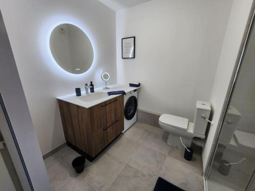 a bathroom with a sink and a toilet and a mirror at Appartement Plein Centre in Saint-Brevin-les-Pins