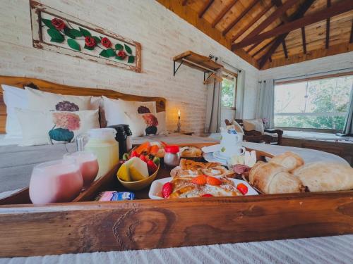 uma bandeja de comida numa cama num quarto em Residencial Vilas Boas MV em Monte Verde