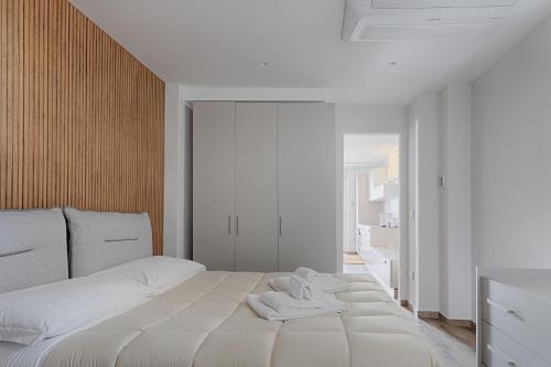 um quarto com uma grande cama branca com duas toalhas em Palazzo Cajeta em Gaeta