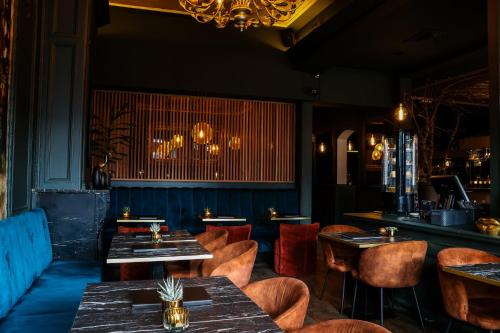 een restaurant met tafels en stoelen en een kroonluchter bij Hotel XL in Zandvoort