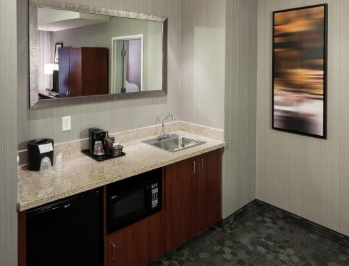 a bathroom with a sink and a mirror at Courtyard by Marriott Santa Clarita Valencia in Valencia