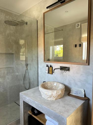 a bathroom with a stone sink and a shower at Casa Malìa Luxury Guest House in Luz