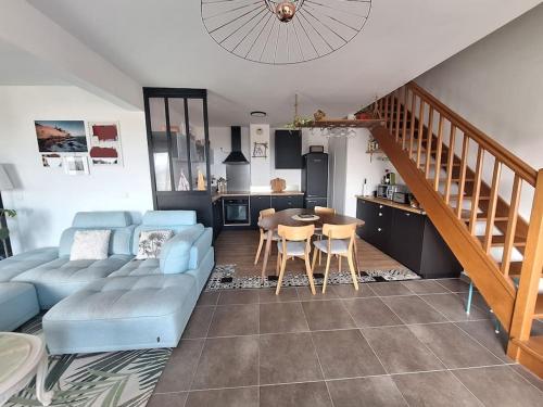 un salon avec un canapé bleu et une cuisine dans l'établissement Appartement 3 pièces vue mer, à Bastia