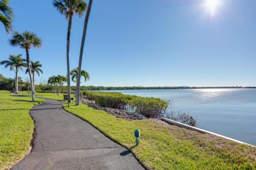 a sidewalk next to a body of water with palm trees at Comfortable Jensen Beach Condo with Pool View! in Jensen Beach