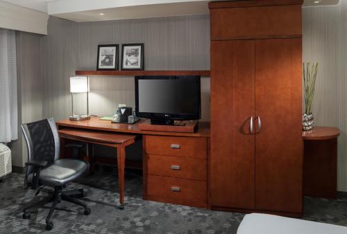 a hotel room with a desk with a television and a chair at Courtyard by Marriott Santa Clarita Valencia in Valencia