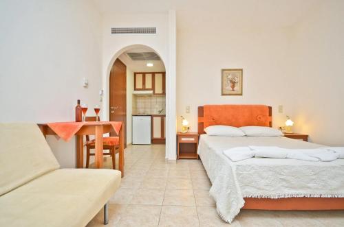 a bedroom with two beds and a table and a couch at Anthi Studios in Agia Anna Naxos