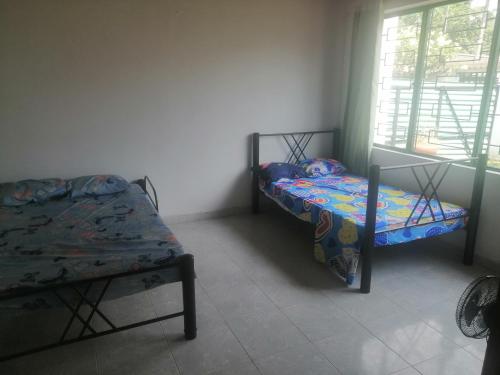 a bedroom with two beds and a window at Villa Rosita in Villeta