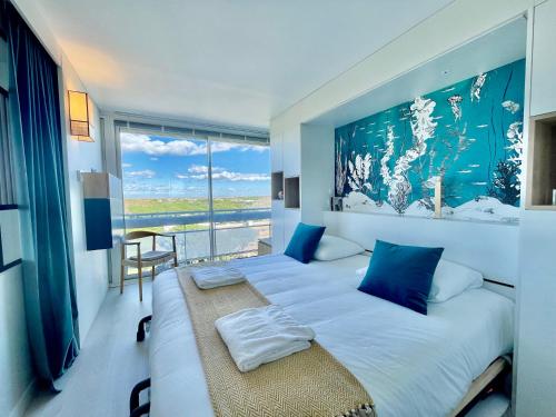 une chambre avec un grand lit avec une grande fenêtre dans l'établissement PGH N30 - Centre-Ville, Roof-Top & Parking Privé, à La Grande Motte