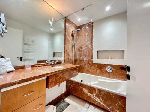 une salle de bain avec une baignoire, un lavabo et une douche dans l'établissement PGH N30 - Centre-Ville, Roof-Top & Parking Privé, à La Grande Motte
