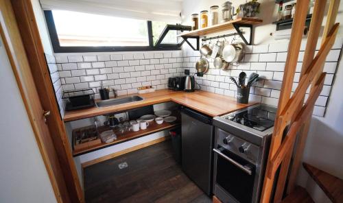 a small kitchen with a sink and a stove at Güer Aike Mejor Tiny house c/ vista al Fitz Roy in El Chalten