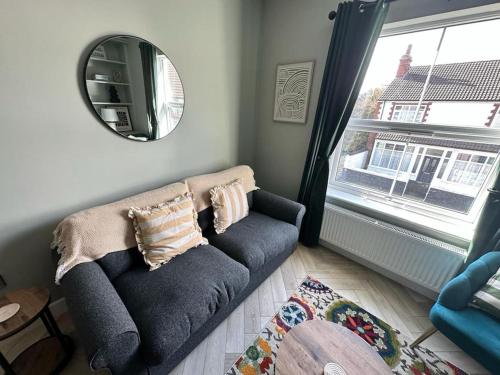 a living room with a couch and a mirror at Bronte Cottage - Quirky, central, 2bed, seaside in Hornsea