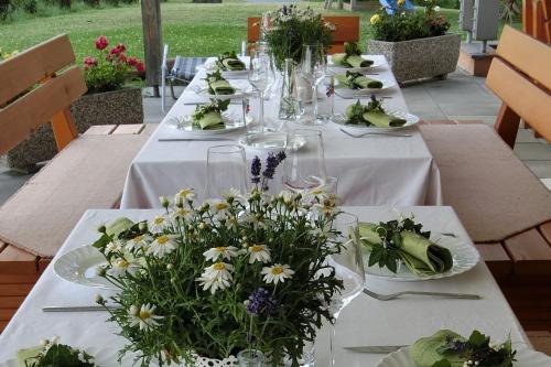 a long table with white tables with flowers on it at Zweytick Gästezimmer Weingut in Ratsch an der Weinstraße