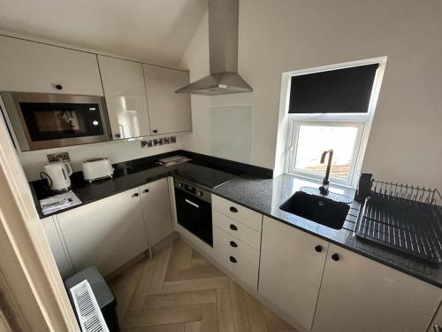 a kitchen with a sink and a microwave at Bronte Cottage - Quirky, central, 2bed, seaside in Hornsea