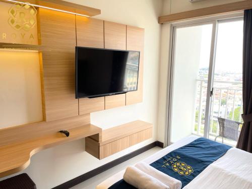 een slaapkamer met een flatscreen-tv aan de muur bij Royal Suites Studio 17th Floor - Citra Plaza Nagoya Apartment in Jodoh