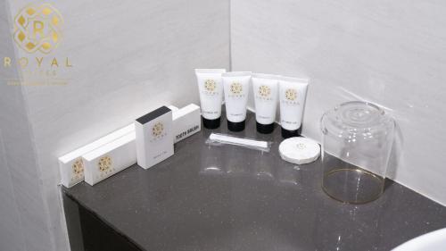 a table with three white vases and a glass container at Royal Suites Studio 17th Floor - Citra Plaza Nagoya Apartment in Jodoh