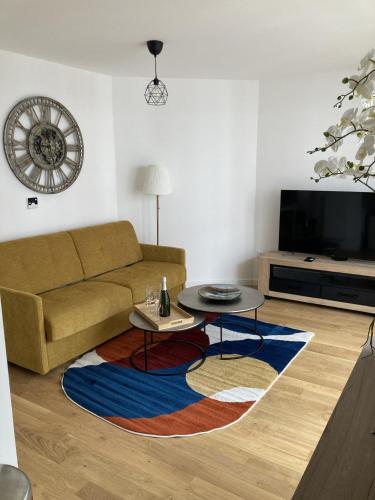 sala de estar con sofá y mesa en Very nice 40 m quiet in Suresnes with parking en Suresnes