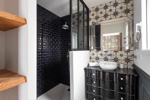 a bathroom with a black tiled wall at La perle de mer - Charmante maison avec jacuzzi in Erquy